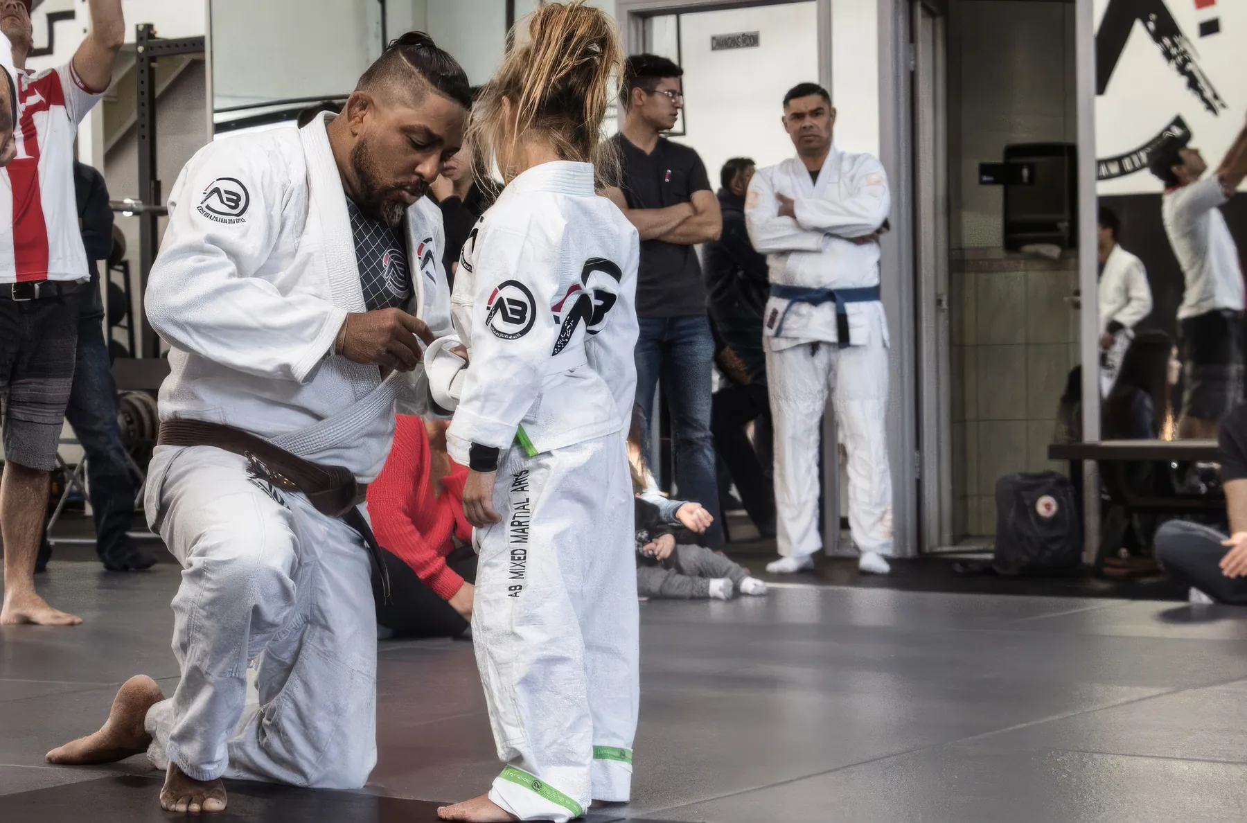 Braga Neto tying a belt at a kids ceremony