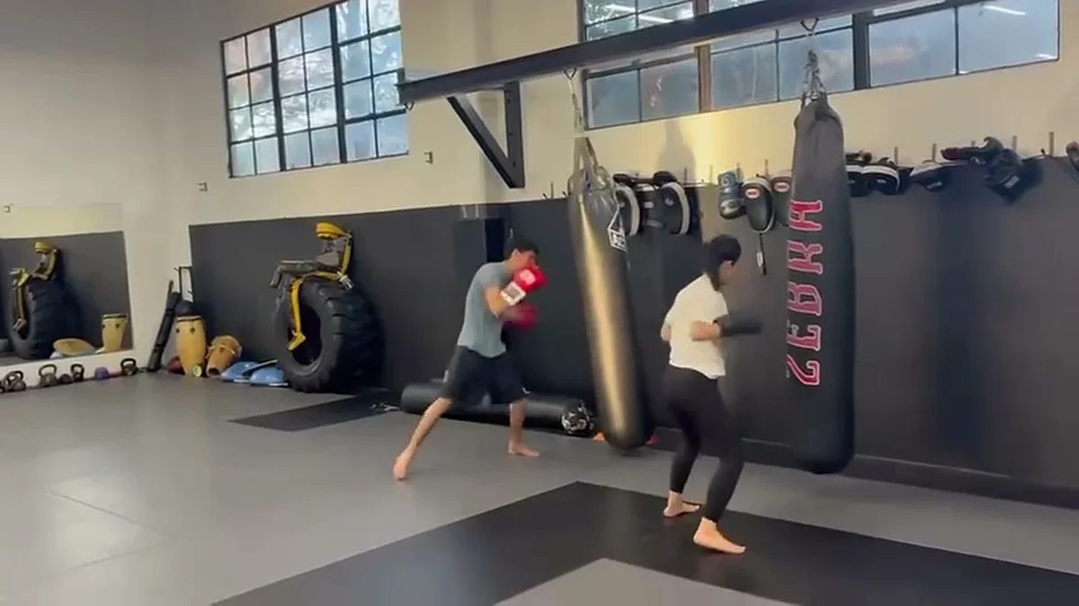Student throwing a Muay Thai kick on a heavy bag at AB MMA on San Bruno Avenue, San Francisco