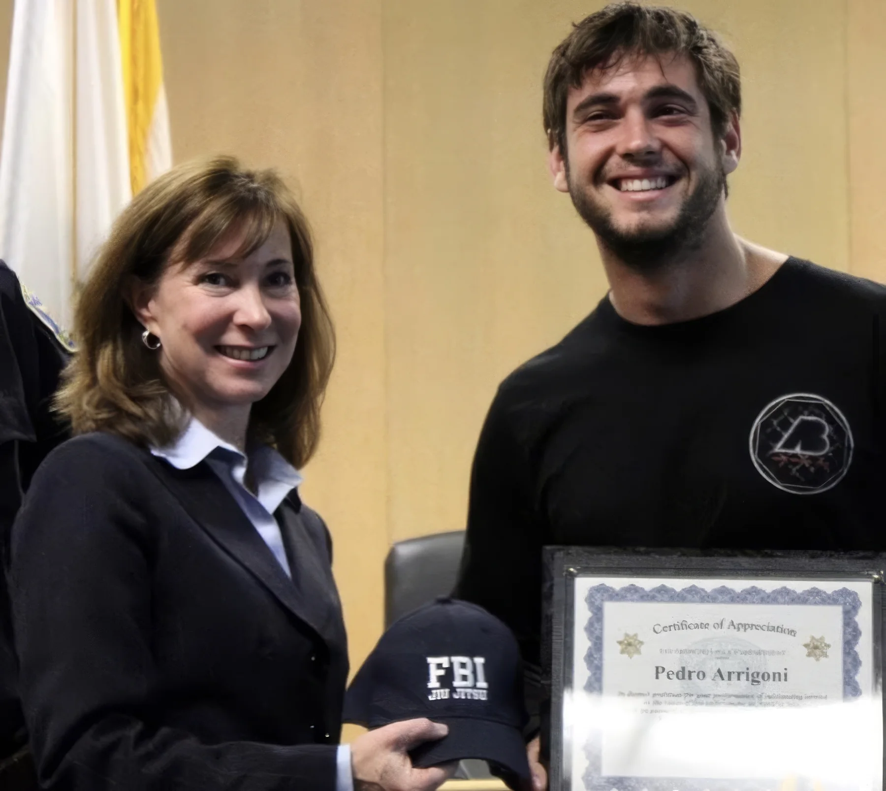 Pedro Arrigoni at the 2011 recognition ceremony, holding his SFPD Certificate of Appreciation and receiving an FBI Jiu Jitsu cap