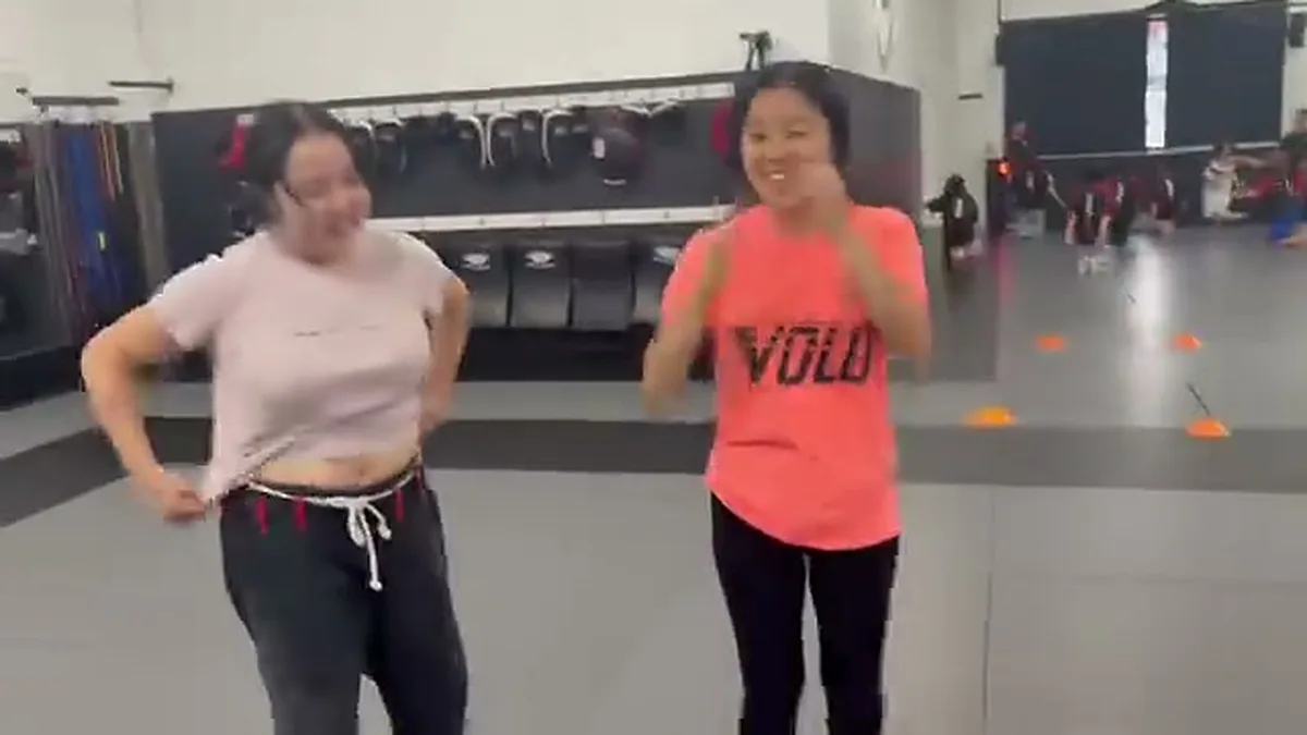 Two women laughing after a self-defense drill at AB Mixed Martial Arts in San Francisco